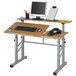 A Safco medium oak drafting table with a computer and keyboard on it.