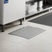A rectangular stainless steel floor trough with a grate, installed in a tiled floor.