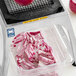 A Vollrath 1/4" dicer assembly on a counter with a container of sliced red onions in it.