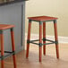 Lancaster Table & Seating Industrial Backless Bar Stools with Rustic Mahogany Finish on a kitchen counter.