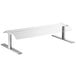 A clear glass and metal Avantco pass-through sneeze guard on a white table.