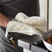 A person using a Choice terry cloth pot holder to grab a pot off the stove.