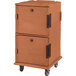 A brown plastic Cambro food pan carrier on wheels.