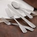 A Walco stainless steel bouillon spoon on a plate.
