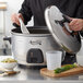 An Avantco stainless steel lid on a large pot of rice and peas.