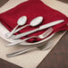 A Walco stainless steel butter knife on a red napkin on a plate.