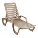 A tan plastic Grosfillex chaise lounge chair with armrests.