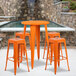 An orange Flash Furniture bar height table with 4 square stools.