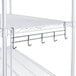 A white metal Regency shelf with 5 chrome utensil hooks.