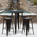 A Flash Furniture bar table with three square stools on an outdoor patio.