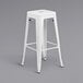 A white metal backless stool with a square seat.