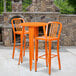 An orange table and chairs on a patio.