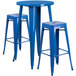 A blue table with a round top and three square seat blue stools.