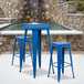 A blue table and two blue square seat backless stools.