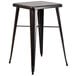 A black metal square bar table with black metal legs with 2 black metal stools with legs.