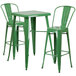 A green metal table with two chairs.