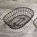 Two American Metalcraft bronze oval wire baskets on a wood surface.