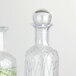 Two clear glass bottles with American Metalcraft glass stoppers.