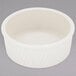 A Tuxton eggshell swirl ramekin on a gray surface.
