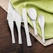 A Walco stainless steel dinner knife on a white plate with a green napkin.