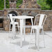 A white metal Flash Furniture table and two bar stools.