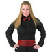 A woman with long blonde hair wearing a Henry Segal black tuxedo shirt and red bow tie.