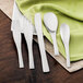 A Walco stainless steel teaspoon on a white plate.