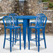 A blue metal bar height table with blue chairs.