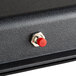 A black metal rectangular sign with a red button.