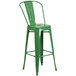 A green metal bar stool with a backrest.