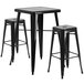 A black metal table with two black metal square bar stools.