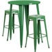 A green metal bar table with a green metal table and two square seat backless stools.