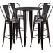 A black metal Flash Furniture bar height table with four black metal chairs.