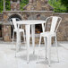 A Flash Furniture white metal bar height table with white metal stools.