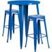 A blue metal bar height table with two blue square seat backless stools.