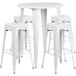 A white round metal table with four square white backless stools.