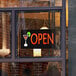 A white rectangular LED sign that says "Open" in a window.