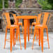 An orange Flash Furniture bar height table with 4 orange chairs.