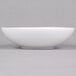 An Arcoroc white soup/cereal bowl on a gray surface.