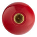 A close-up of a red Henny Penny knob with a gold metal cap.