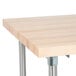 An Advance Tabco wood top work table with a stainless steel base and undershelf.