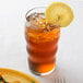 A Libbey iced tea glass with a lemon slice in the tea.