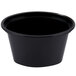 A black Newspring oval souffle container with a clear lid.