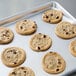 A Chicago Metallic aluminum sheet pan with a tray of chocolate chip cookies on it.