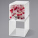 A white square container with ice and cherries inside.