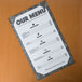 A black menu with a marble design on a table.