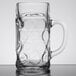 A Stolzle glass beer mug with a handle and a circular design.