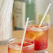 Two glasses of drinks with Choice white wrapped sip straws on a table.