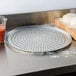 An American Metalcraft super perforated heavy weight aluminum pizza pan with dough on it.