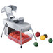 An Edlund electric vegetable slicer with tomatoes and other fruits on the counter.